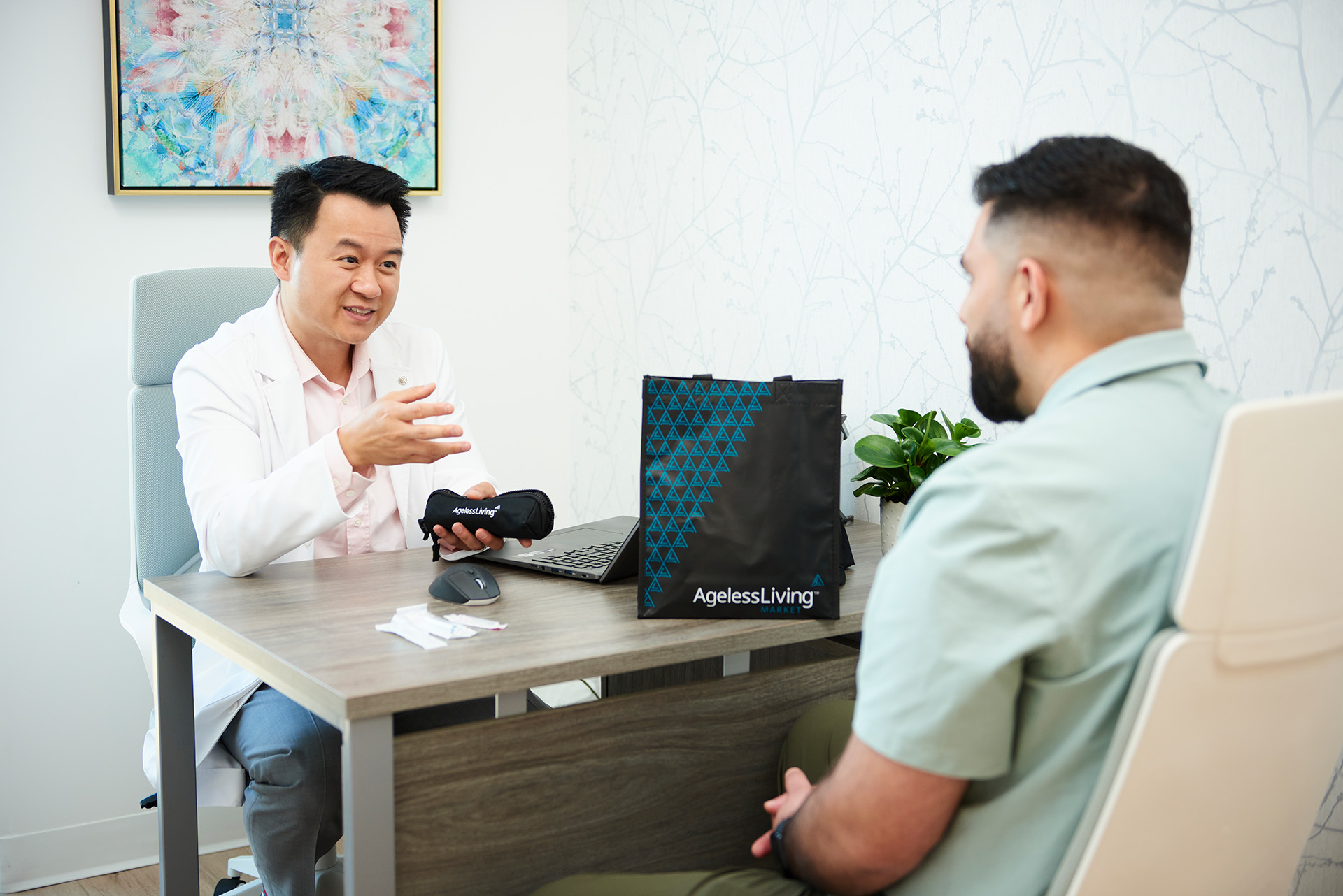 An Ageless Living physician talking a patient through a plan across the desk